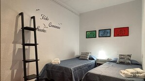 A room with two beds, a ladder, and a wall with a motivational quote. - "Domus Font" - Apartment in Plaça de la Font (Tarragona)