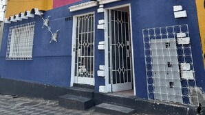 Un bâtiment aux couleurs vives, avec une partie inférieure bleue, une partie supérieure jaune et une partie centrale rose.