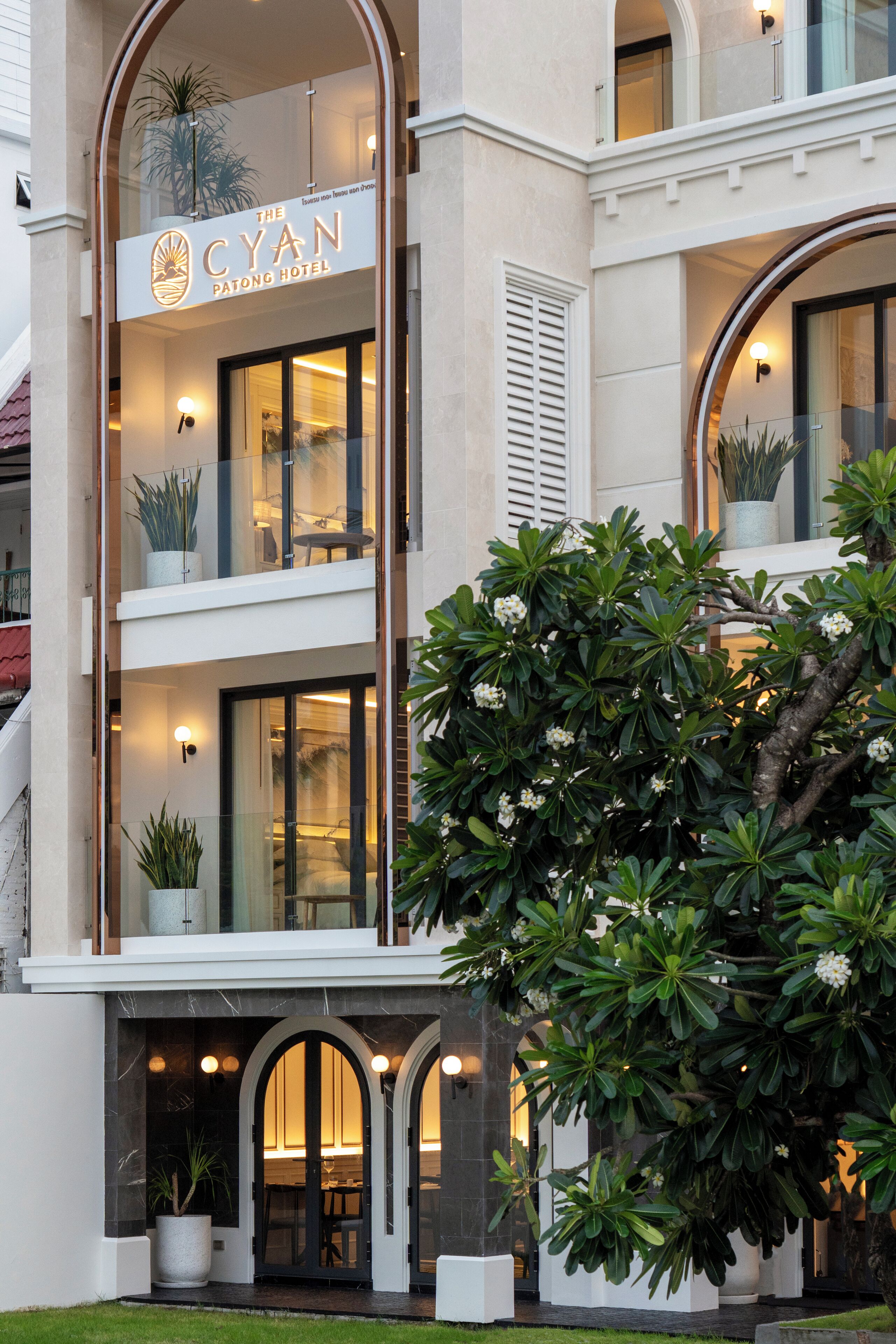 Un hotel con fachada moderna, ventanas amplias y plantas en macetas.