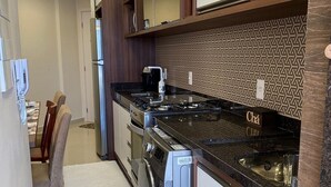 A modern kitchen with a gas stove, built-in oven, and a dishwasher. - Resid. Clube Mar Grosso-Laguna - LAG605 (Laguna)