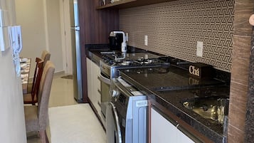 Une cuisine moderne équipée d’une cuisinière à gaz, d’un four encastré et d’un lave-vaisselle.
