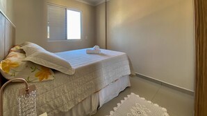 Ein Schlafzimmer mit einem Bett, einem Fenster und einer Deckenleuchte.