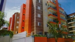 Un immeuble résidentiel à plusieurs étages, doté d’une architecture moderne, avec des balcons et une variété de modèles de fenêtres.