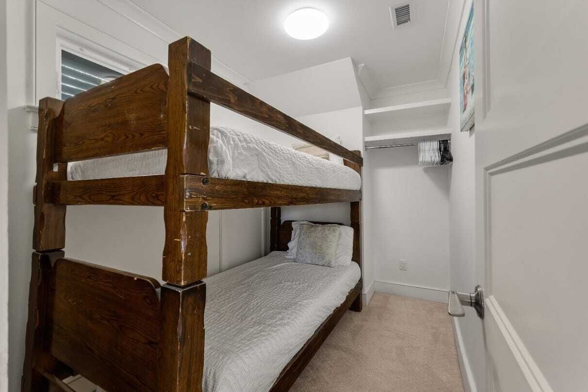 A bunk bed in a room with a closet and a door.