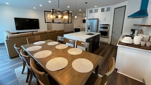 A modern kitchen with white cabinets, a built-in oven, and a microwave.