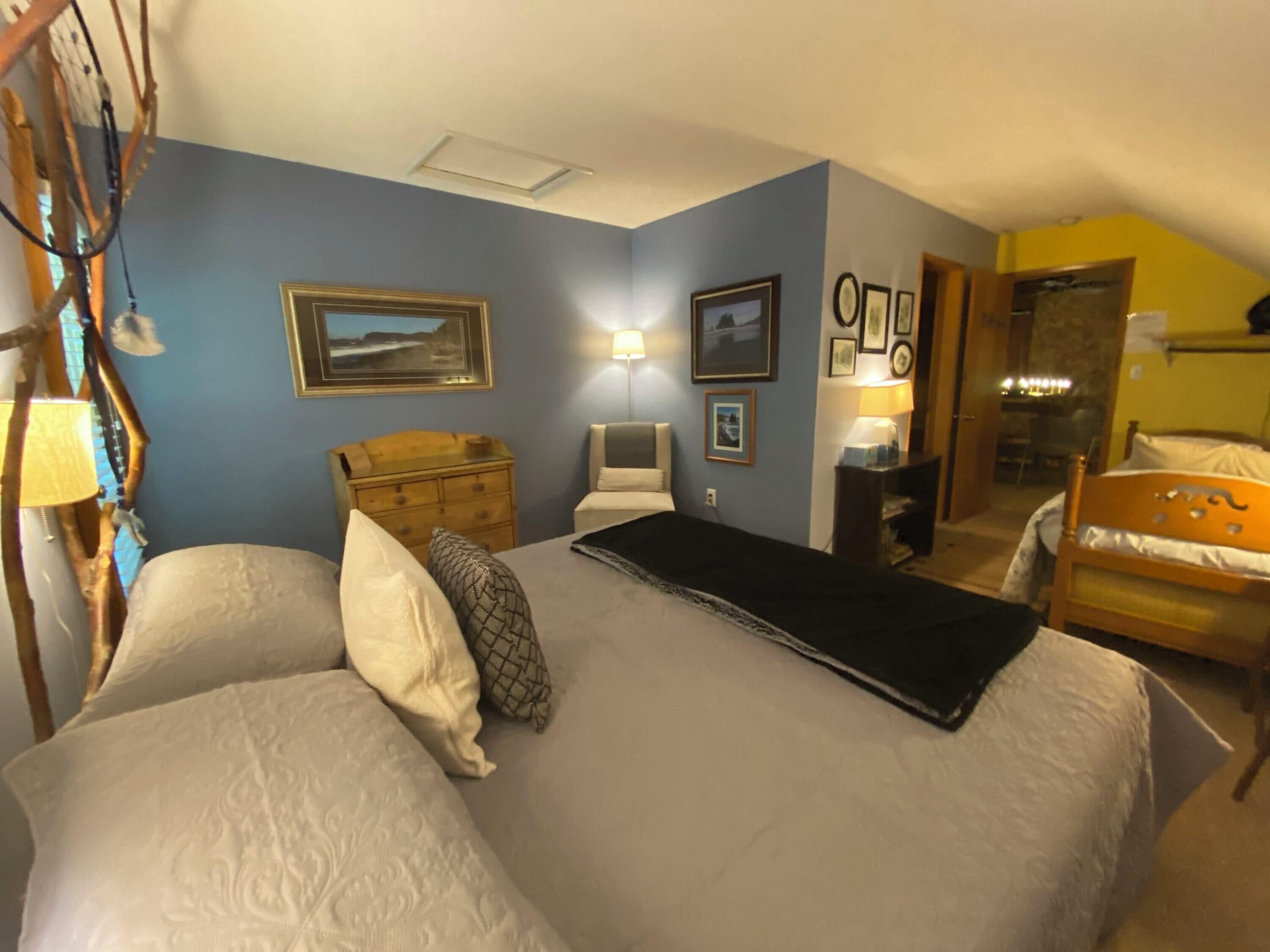A bedroom with a bed, a dresser, a chair, and a desk.