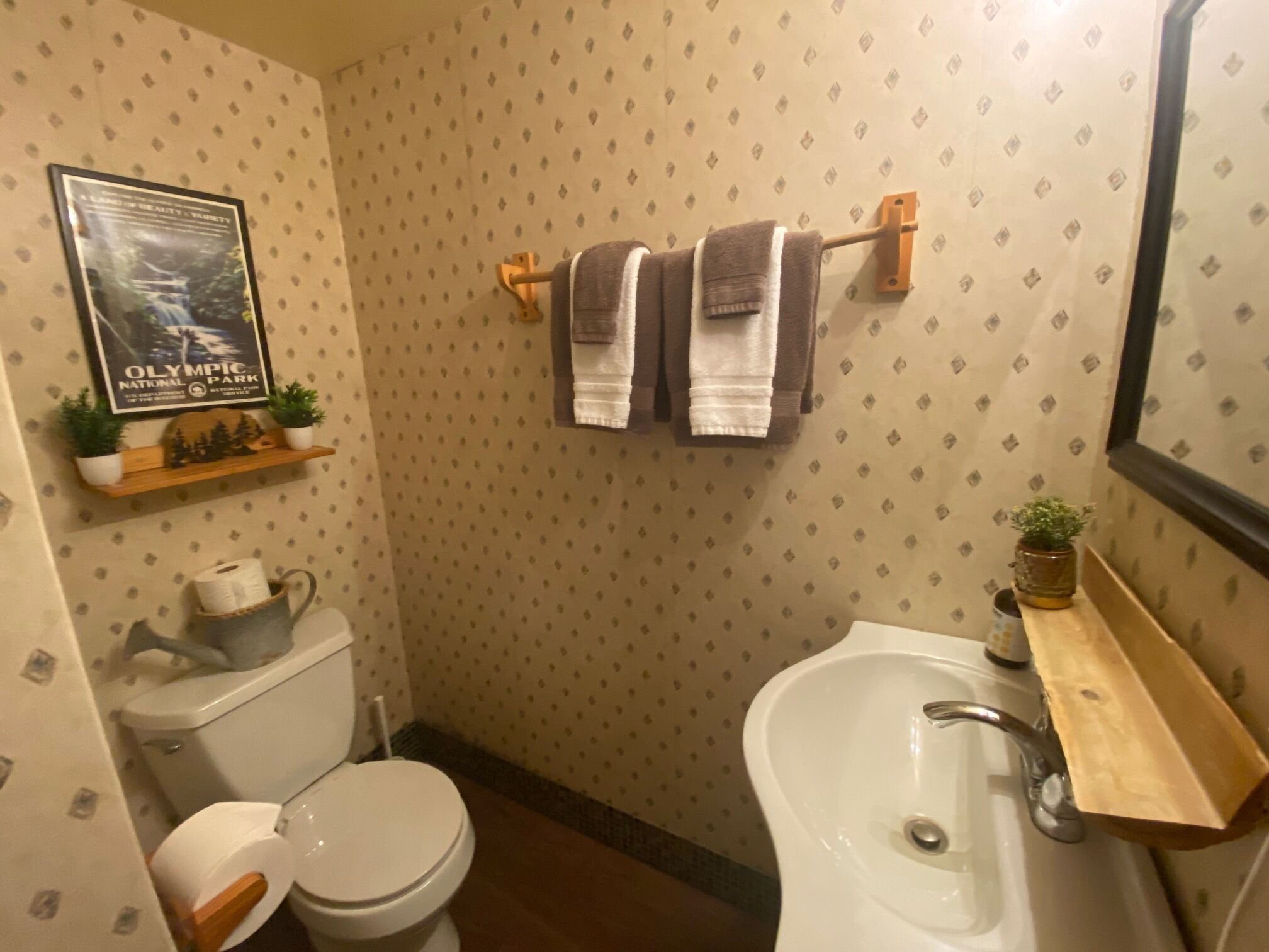 Un baño con inodoro, lavamanos y perchero para toallas.