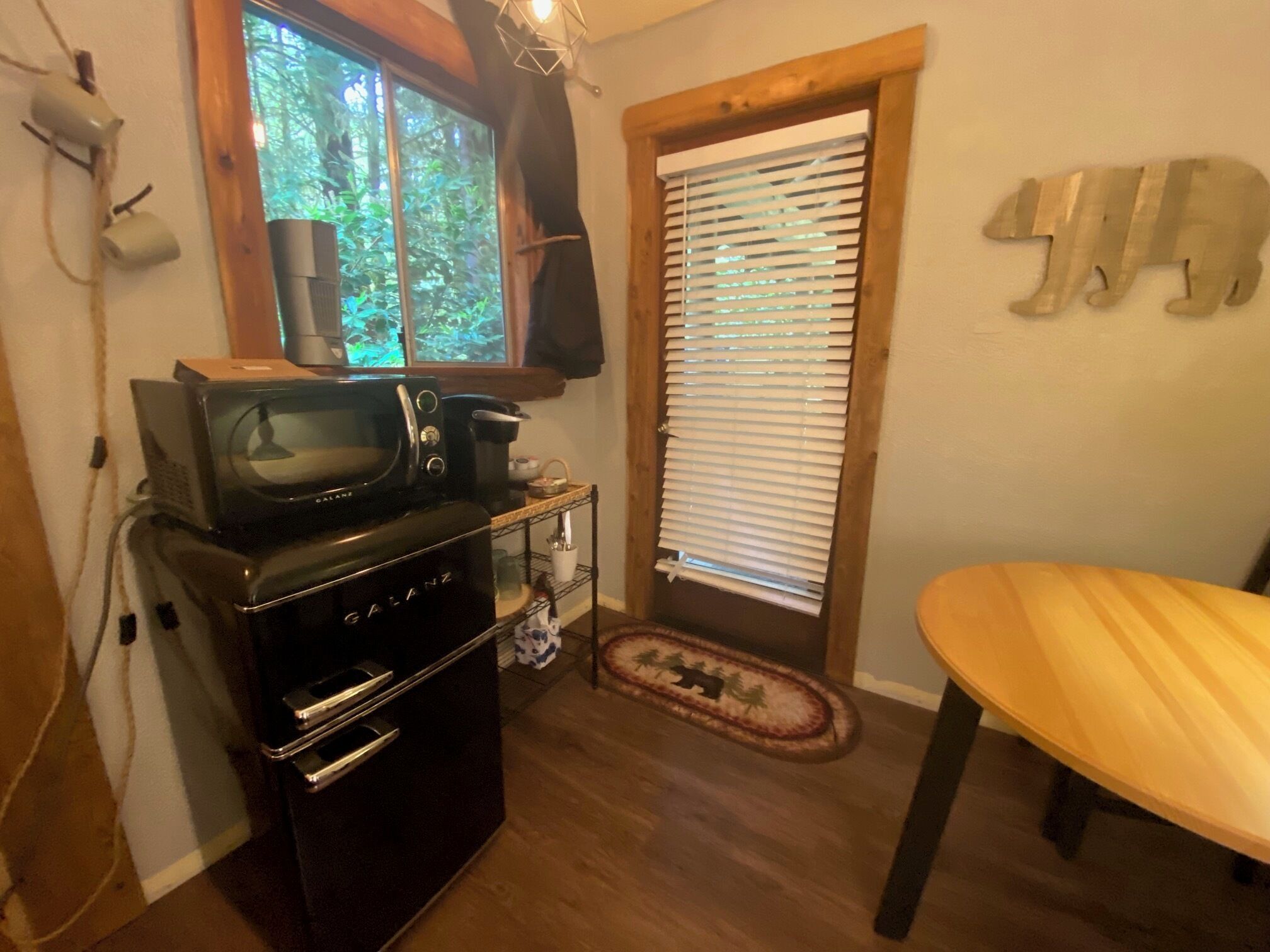 A compact kitchen with a microwave, oven, and a small table.