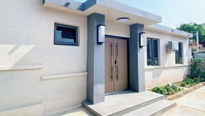 A modern building with a beige facade, a central door, and a small window. - Changdao Shuanglin Homestay (Yantai)