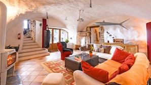 Ein gemütliches Wohnzimmer mit Steinwand, Kamin, Sofa und Couchtisch.