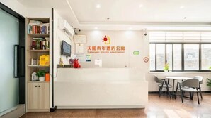 A clean, modern youth apartment with a reception desk, a bookshelf, and a dining area with chairs. - Shanghai Tianyang Hotel (Huangxing Road Subway Station) (Shanghai)