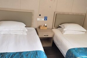 A hotel room with two beds, a nightstand, and a small drawer. - Shanghai Tianyang Hotel (Huangxing Road Subway Station) (Shanghai)