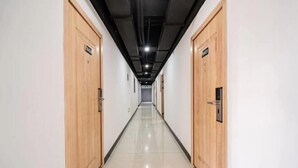 A long, narrow hallway with wooden doors on either side, each marked with a sign. - Shanghai Tianyang Hotel (Huangxing Road Subway Station) (Shanghai)