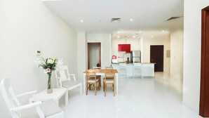 A modern apartment with a dining area, kitchen, and a living space.