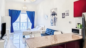 A modern apartment with a kitchen, dining area, and a bedroom.