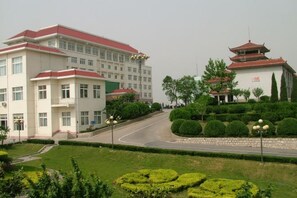 A building with a red roof and a traditional pagoda-style structure. - Xincheng Hotel (Yiyuan)