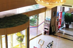 Un vestíbulo con una mesa de recepción, una máquina expendedora y una planta en maceta.