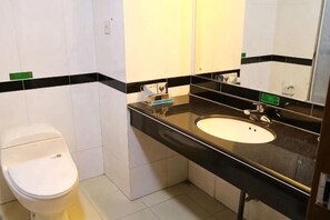 Ein Badezimmer mit Toilette, Waschbecken und Spiegel.