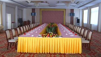 A conference room with a long table, chairs, and a carpeted floor.