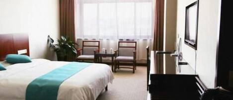 Una habitación de hotel con una cama, un escritorio, una silla, una planta en maceta y una ventana.
