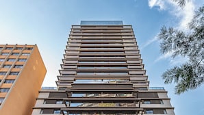 Un immeuble moderne de grande hauteur, doté de nombreux balcons, de grandes fenêtres et d’une enseigne indiquant « Huis Introit ».