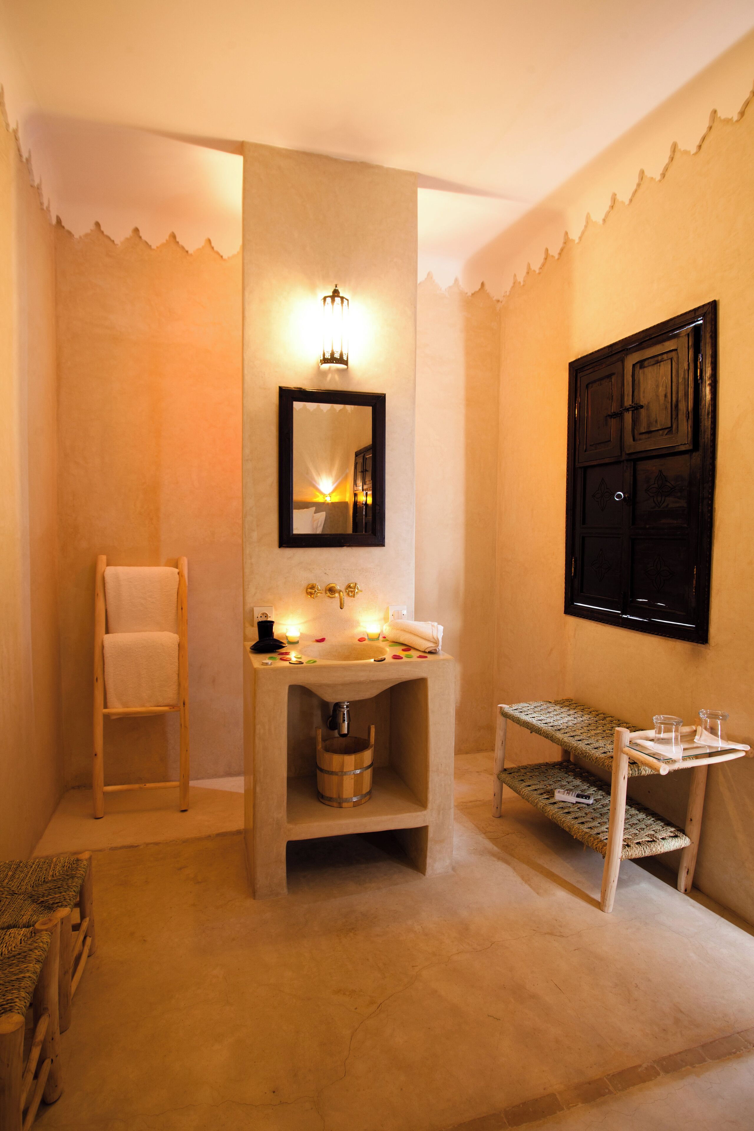 A bathroom with a sink, mirror, towel rack, and a small shelf with toiletries.