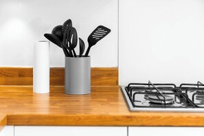 A kitchen counter with a gas stove and a utensil holder containing various kitchen tools.