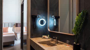 Un baño moderno con un espejo grande, un lavabo y un banco.