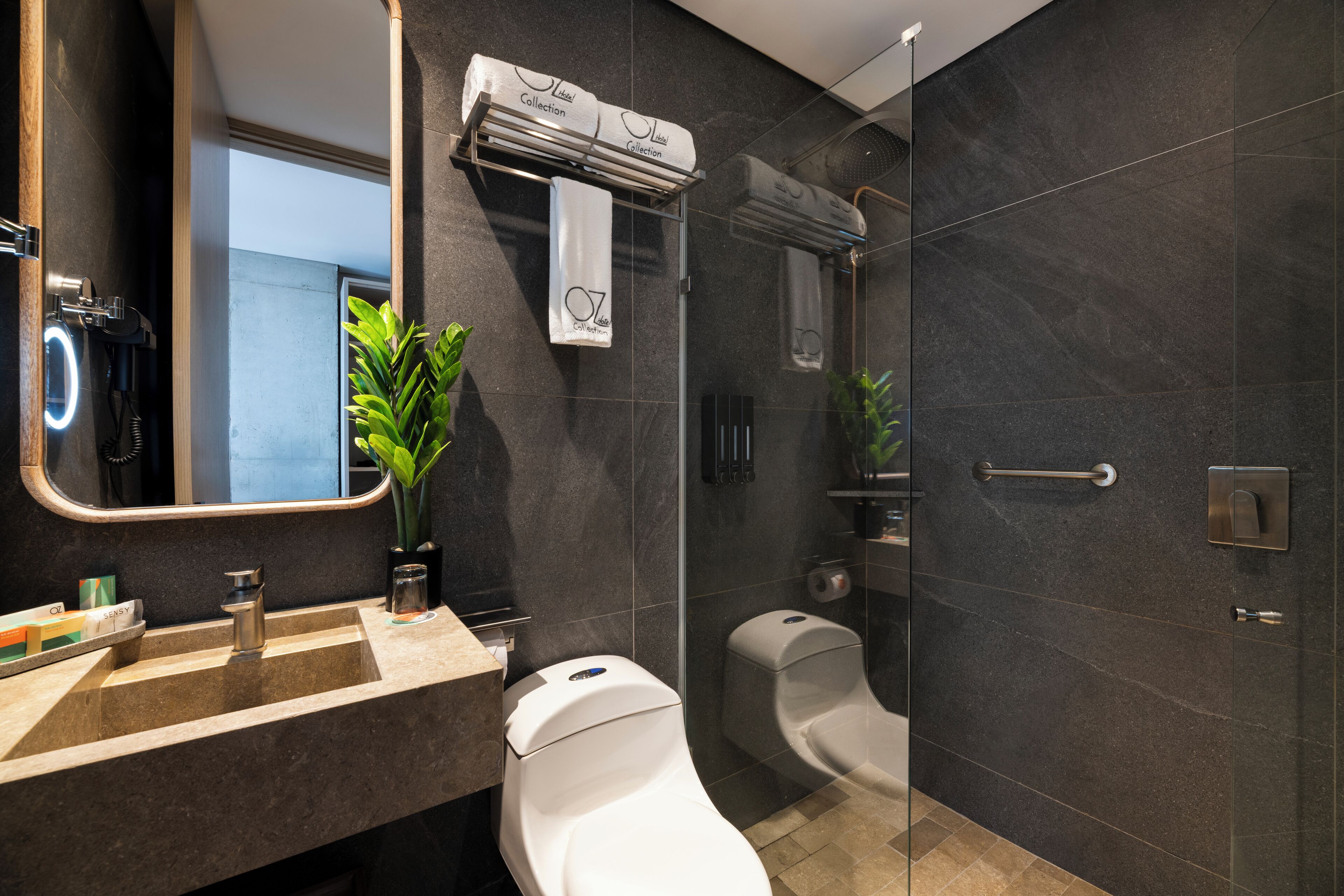 Un bagno moderno con uno specchio grande, un lavandino, un water e una zona doccia.