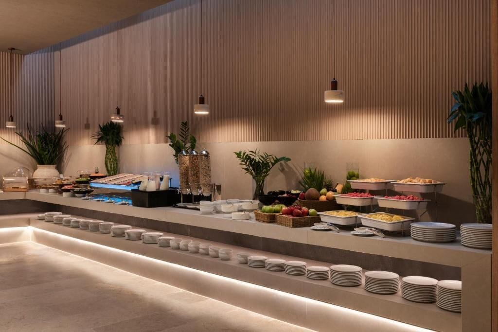 A buffet setup with various food items and stacked plates.