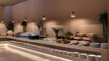 A buffet setup with various food items and stacked plates.