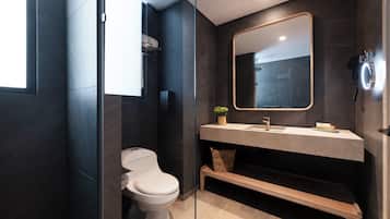 Une salle de bain moderne avec des toilettes, un lavabo et un miroir.