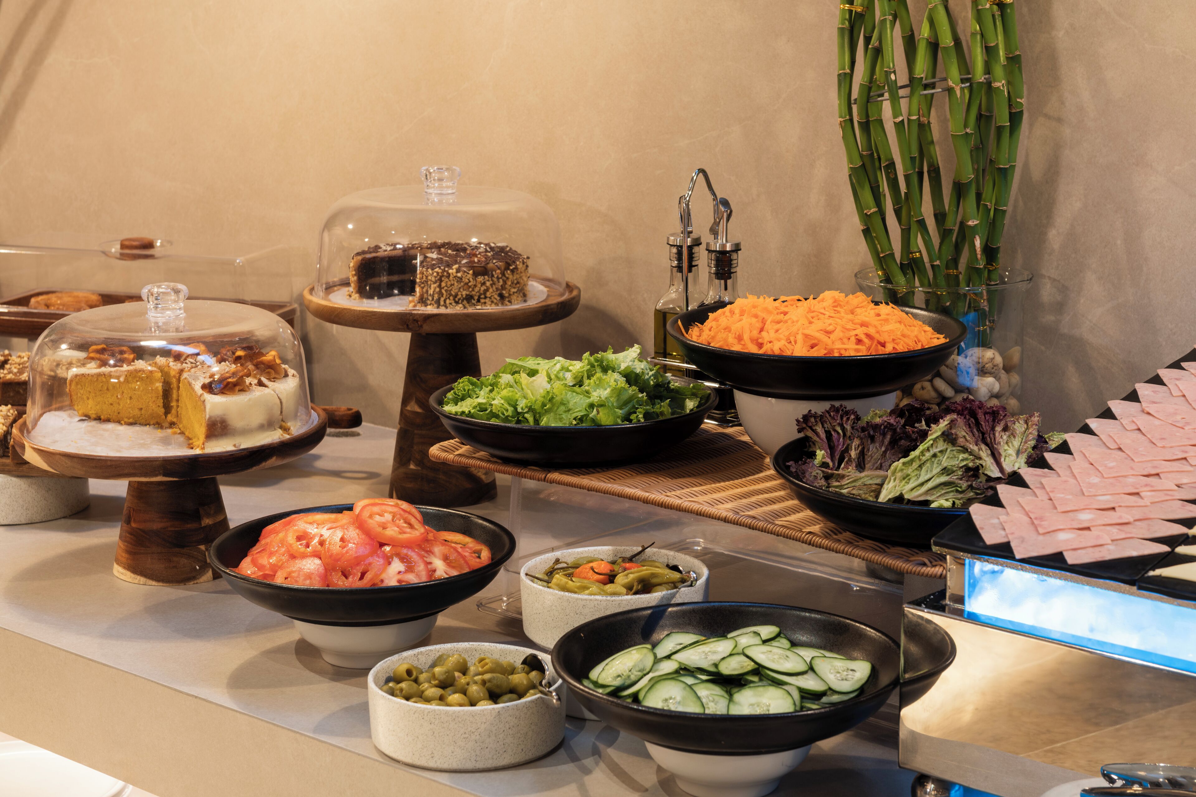 A buffet with various food items including cakes, salads, and meats.