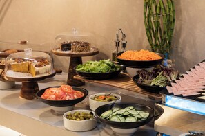 A buffet with various food items including cakes, salads, and meats. - OZ Hotel Collection (Cartagena)