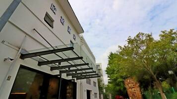 A building with a modern facade, large glass windows, and a metal awning.