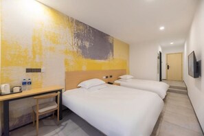 A hotel room with two beds, a desk, and a chair. - Xinyu Hotel (Shanghai)