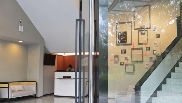Un espace d’accueil comprenant un comptoir de réception, un canapé et un escalier.