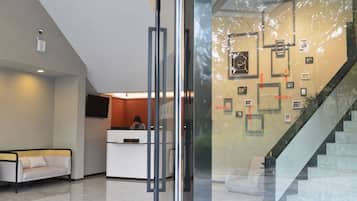 A reception area with a reception desk, a sofa, and a staircase.
