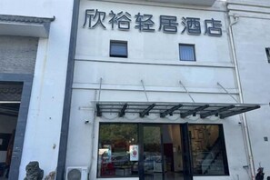 A hotel with a sign above the entrance. - Xinyu Hotel (Shanghai)