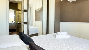 A hotel room with a bed, a mirror, a bathroom, and a small desk. - Resid. Clube Mar Grosso-Laguna - LAG604 (Laguna)