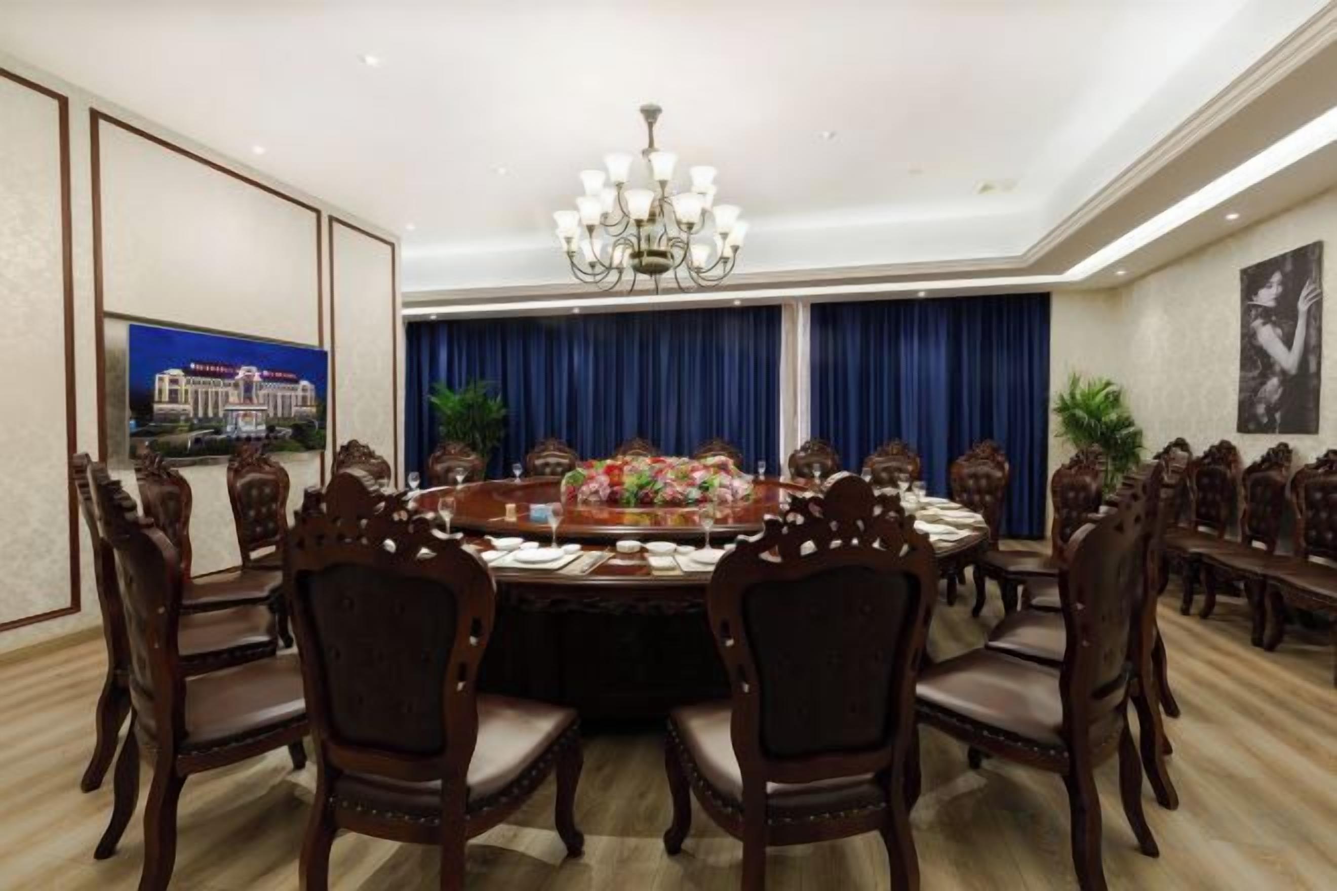Une salle à manger élégante, avec une table ronde, des chaises et un lustre.