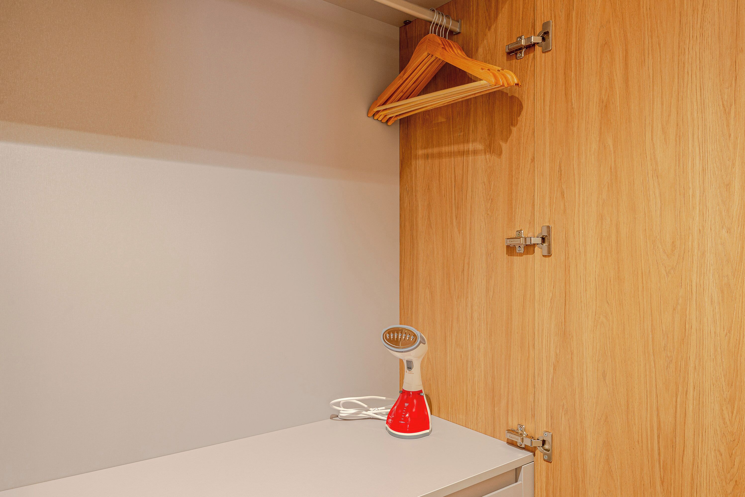 Une armoire en bois avec un plan de travail blanc et un appareil électroménager rouge.