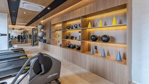 A gym with treadmills, exercise balls, and kettlebells.