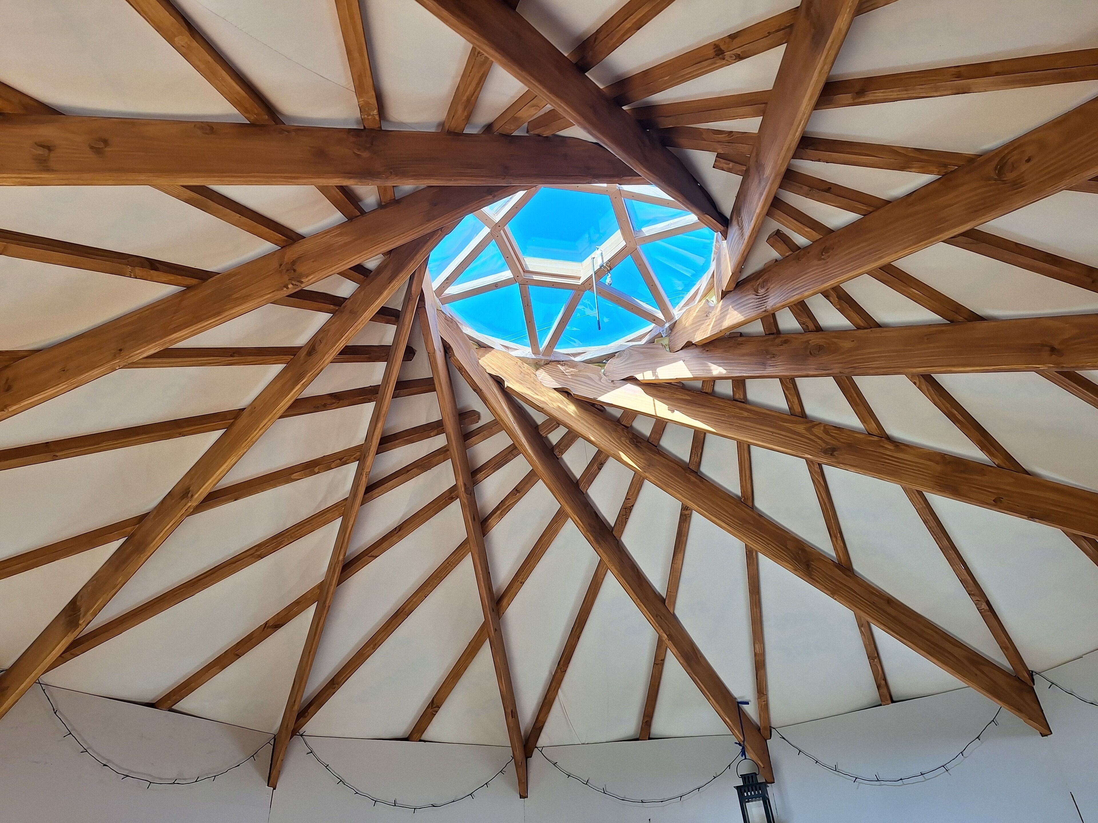 A wooden ceiling structure with a skylight.