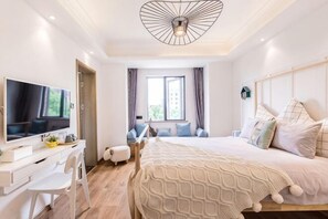 A modern bedroom with a bed, TV, desk, and seating area. - Diqu Manwu Homestay (Shanghai International Tourism Resort Branch) (Shanghai)