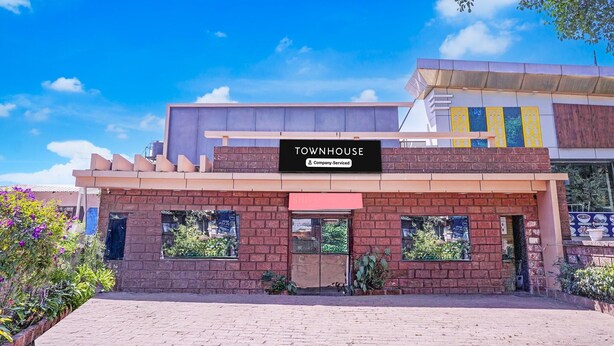 A building with a sign reading 'TOWNHOUSE' and a company-serviced logo.