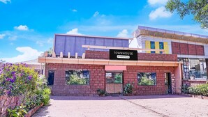A building with a sign reading 'TOWNHOUSE' and a company-serviced logo.