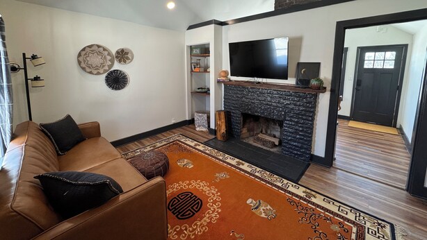 A living room with a fireplace, a sofa, a television, and a ceiling fan. - Cozy Cottage House in Louisville (Louisville)
