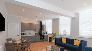 A modern living space with a dining area, kitchen, and seating area. - 2 Bedroom Deluxe (Scarborough)