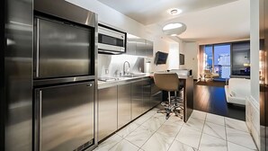 A modern kitchen with stainless steel appliances, a bar area, and a seating space. - Palms Place Hotel StripView (Las Vegas)